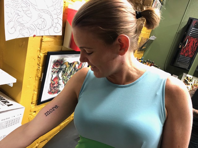 Mandy Jenkins looks at her right arm, which has a tattoo that reads "more."